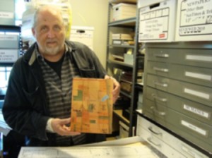 Bob is holding a map from 1883, before Cochran's time, showing where the Bryn Mawr train station was going to go.